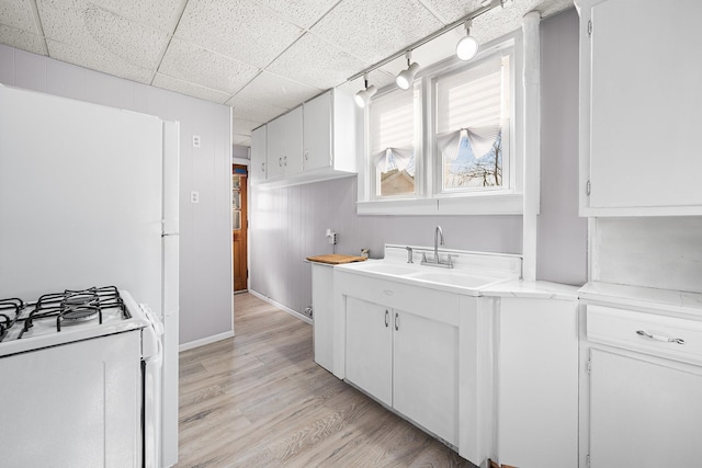 kitchen featuring white cabinetry, white range with gas cooktop, and sink