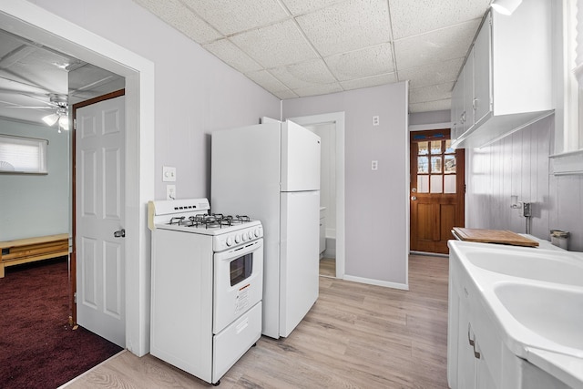 kitchen with white cabinetry, light wood-type flooring, ceiling fan, white appliances, and a drop ceiling