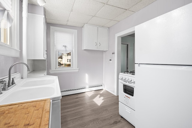 kitchen featuring white cabinetry, a paneled ceiling, hardwood / wood-style flooring, white appliances, and a baseboard heating unit