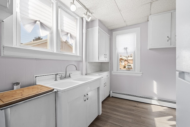 kitchen with baseboard heating, plenty of natural light, dark wood-type flooring, and white cabinets