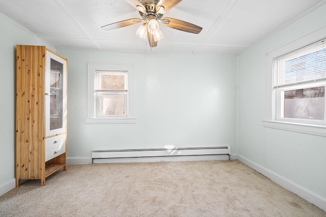 carpeted empty room with a baseboard radiator, plenty of natural light, and ceiling fan