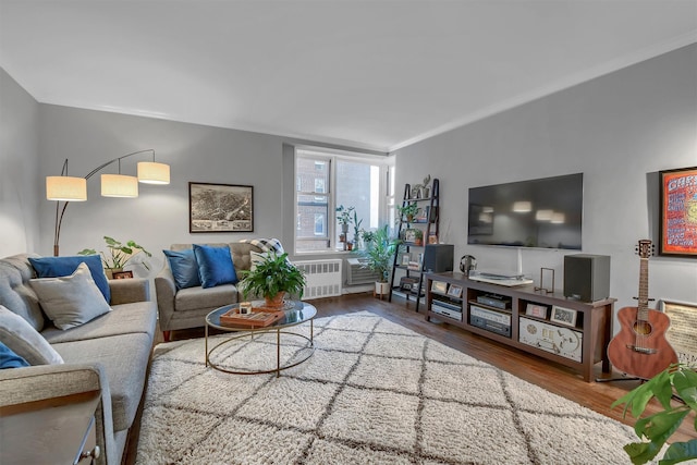 living room with ornamental molding, radiator, and hardwood / wood-style flooring