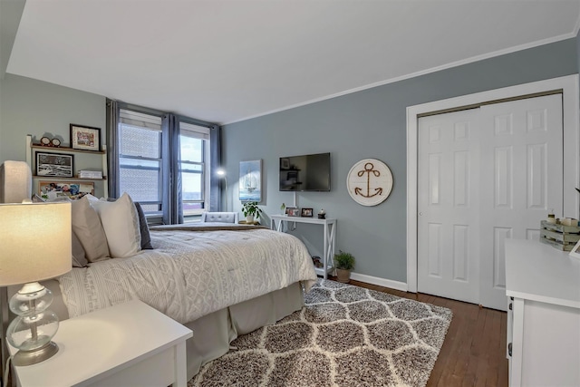 bedroom with dark hardwood / wood-style flooring, ornamental molding, and a closet