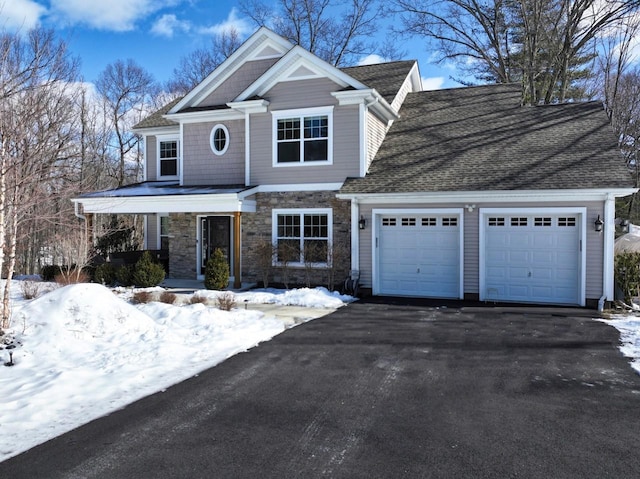 view of front of property with a garage, stone siding, aphalt driveway, and covered porch