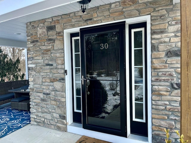 doorway to property featuring stone siding