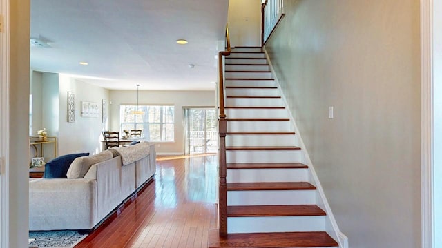 stairs featuring wood finished floors and baseboards