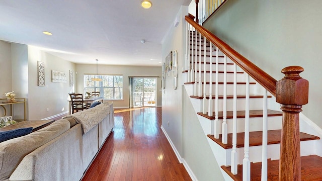 hall with dark wood-style floors, stairs, baseboards, and recessed lighting