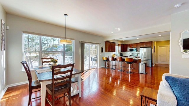 dining space featuring recessed lighting, wood finished floors, and baseboards