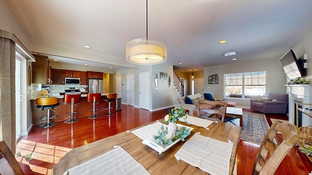 living room with baseboards, stairway, wood finished floors, a fireplace, and recessed lighting