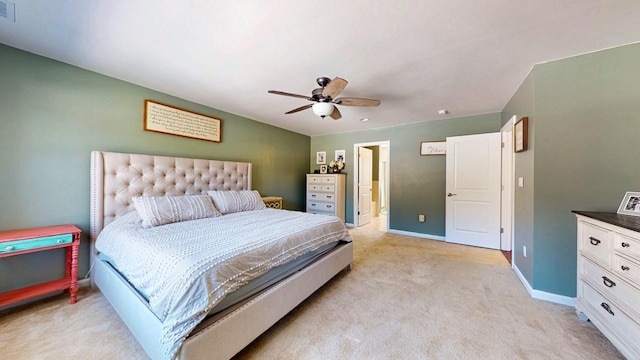 bedroom with light carpet, a ceiling fan, visible vents, baseboards, and ensuite bath