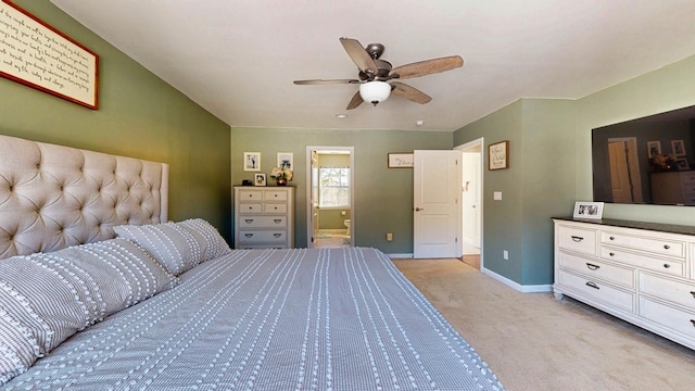 bedroom with baseboards, connected bathroom, a ceiling fan, and light colored carpet