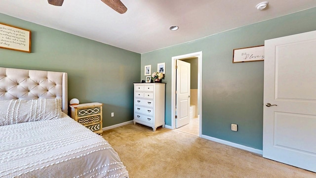 bedroom with light carpet, ceiling fan, ensuite bathroom, and baseboards