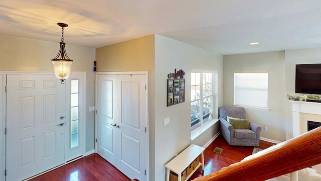 entryway featuring a fireplace, recessed lighting, visible vents, dark wood-type flooring, and baseboards