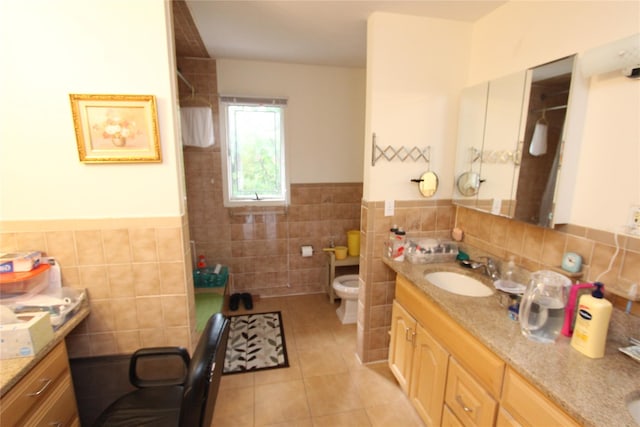 bathroom featuring vanity, toilet, tile patterned flooring, and tile walls