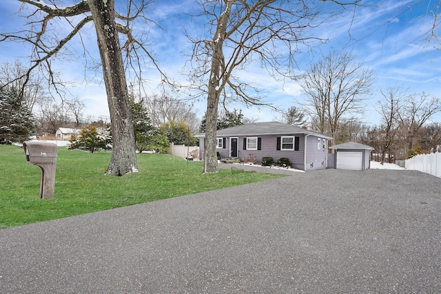 ranch-style house with a garage, an outdoor structure, and a front yard