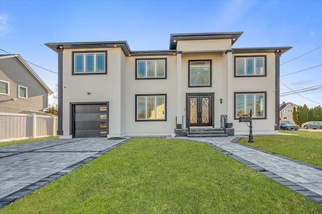 view of front facade featuring french doors, a garage, and a front lawn