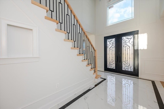 foyer with french doors and a towering ceiling