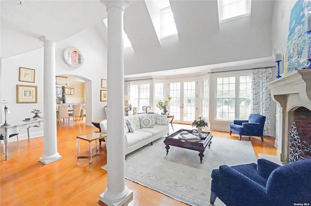 living room featuring decorative columns, a healthy amount of sunlight, and hardwood / wood-style flooring