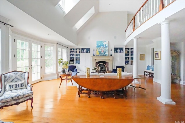 living room featuring hardwood / wood-style floors, decorative columns, and french doors