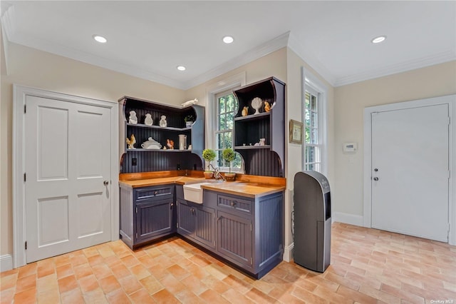 kitchen featuring ornamental molding, sink, and butcher block countertops