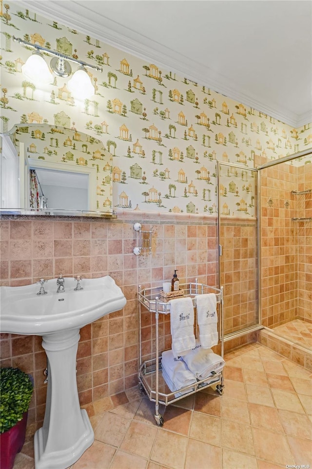 bathroom with tile patterned flooring, crown molding, tile walls, and walk in shower