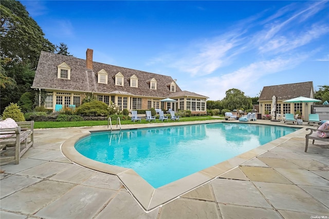 view of pool featuring an outbuilding and a patio area