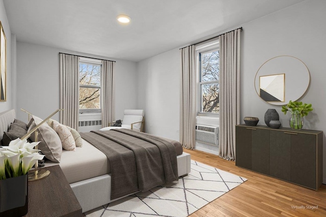 bedroom with multiple windows and light wood-type flooring