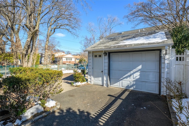 detached garage with fence and driveway