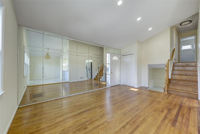 interior space with visible vents, lofted ceiling, light wood-style flooring, stairs, and recessed lighting