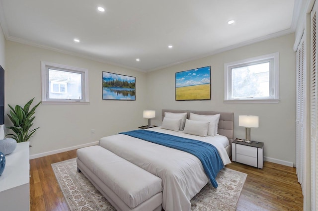 bedroom with multiple windows, crown molding, and wood finished floors