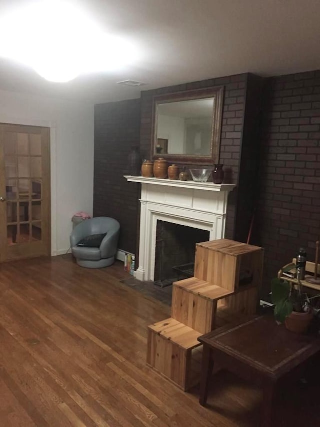 living room with a fireplace and wood-type flooring