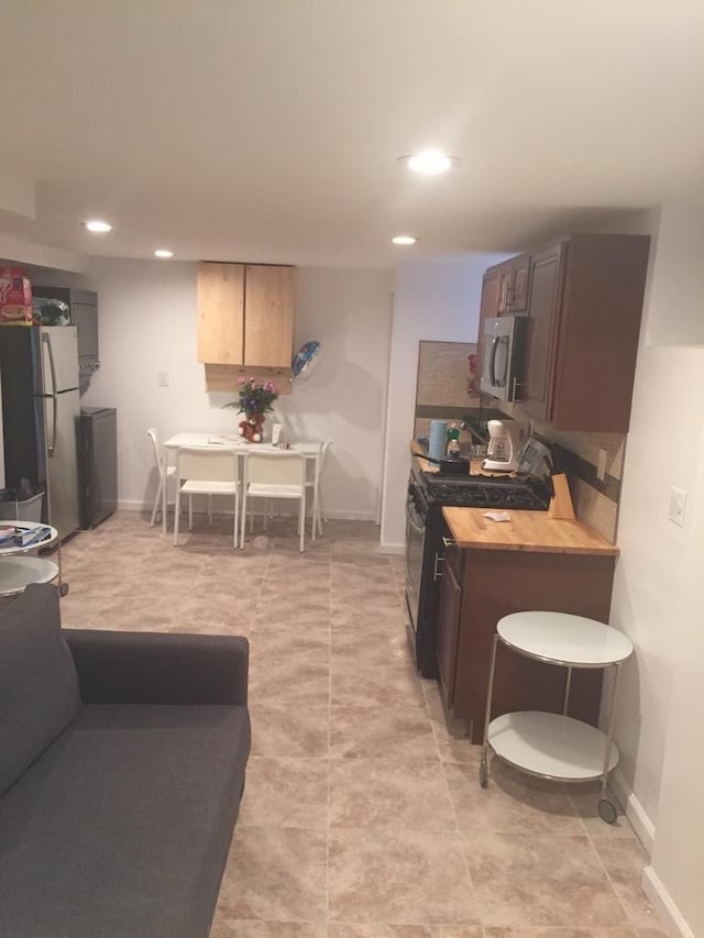 kitchen featuring appliances with stainless steel finishes and wood counters