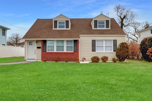 cape cod house with a front yard