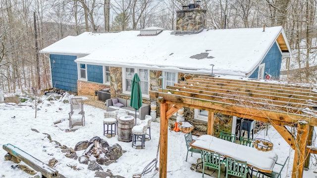 view of snow covered back of property