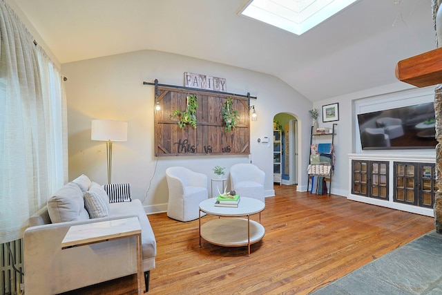 living room featuring hardwood / wood-style floors, radiator heating unit, and lofted ceiling with skylight