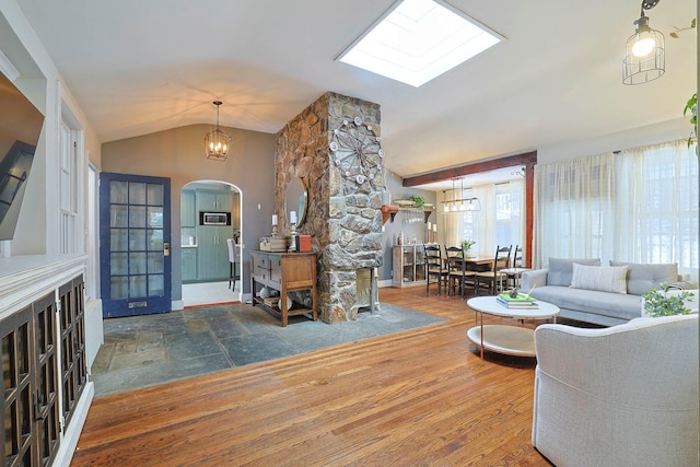 entrance foyer with a chandelier, vaulted ceiling, and hardwood / wood-style floors