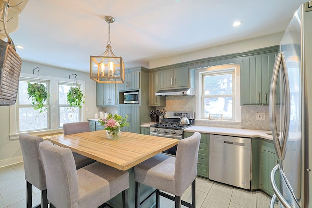 kitchen with tasteful backsplash, appliances with stainless steel finishes, and a wealth of natural light