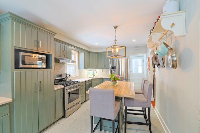 kitchen featuring hanging light fixtures, green cabinets, plenty of natural light, and appliances with stainless steel finishes