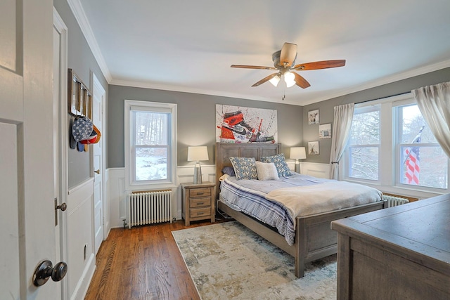 bedroom featuring multiple windows, dark hardwood / wood-style floors, and radiator heating unit