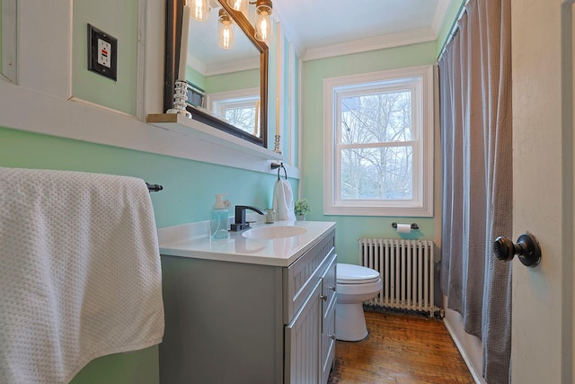 bathroom with hardwood / wood-style floors, radiator heating unit, vanity, ornamental molding, and toilet