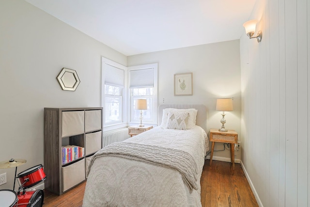 bedroom featuring radiator heating unit and wood-type flooring