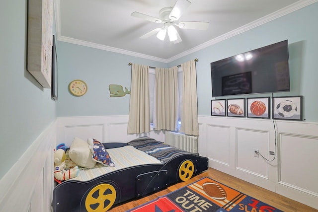 bedroom featuring hardwood / wood-style flooring, ceiling fan, radiator heating unit, and crown molding