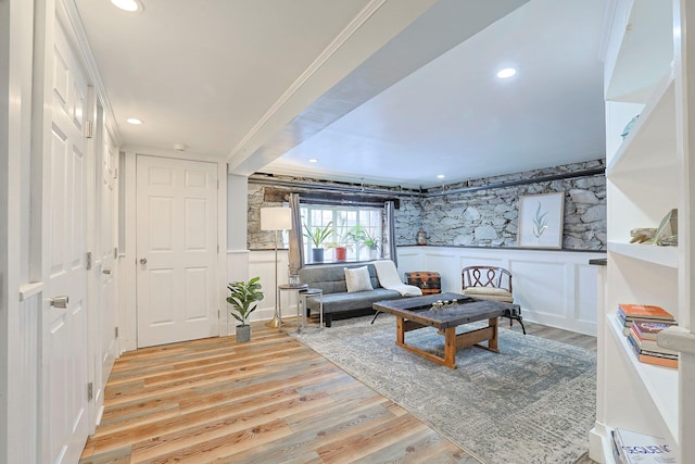 living room featuring ornamental molding and light wood-type flooring