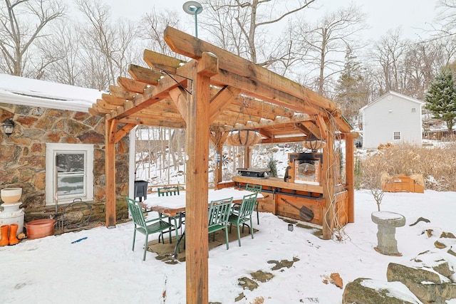 snow covered patio featuring a pergola