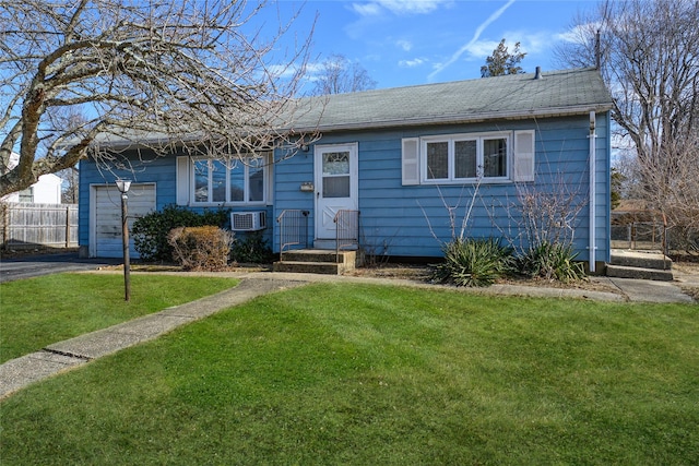 ranch-style house featuring a garage, aphalt driveway, a front yard, and fence