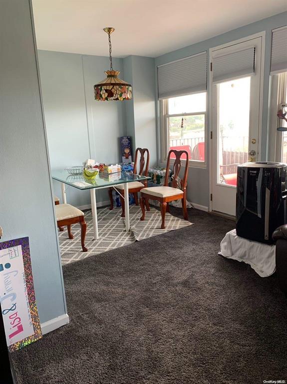 dining room featuring dark colored carpet