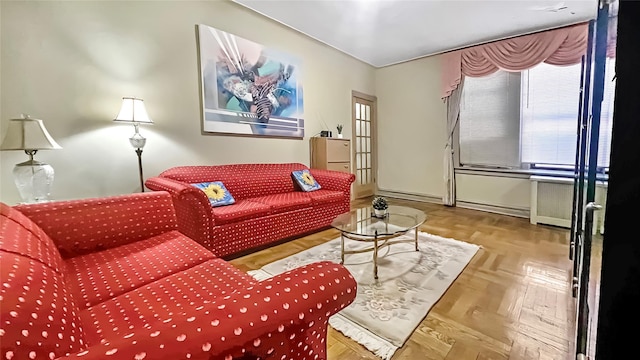 living room with radiator, light parquet floors, and a baseboard heating unit