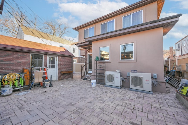 rear view of house featuring ac unit, a patio, and stucco siding