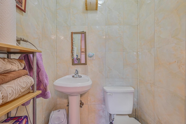 bathroom with toilet and tile walls