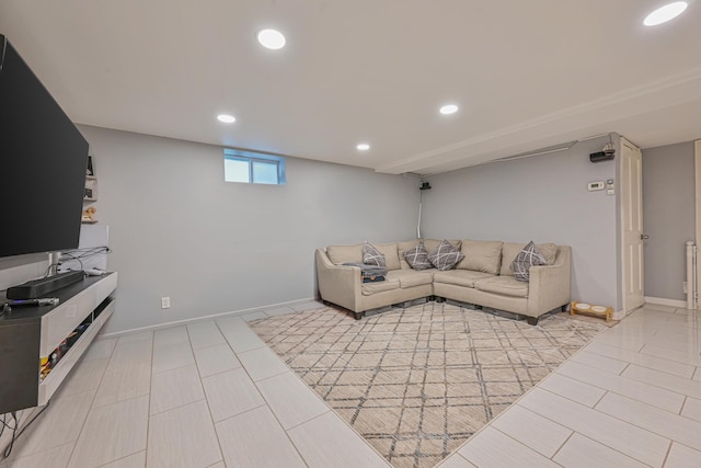 living area featuring baseboards, radiator heating unit, and recessed lighting